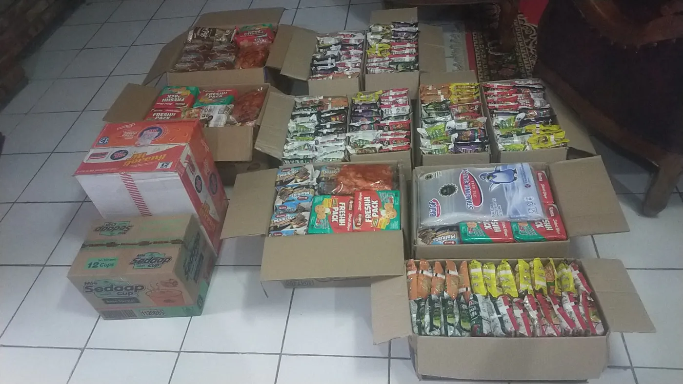 Kardus mi instan dan camilan disusun saat pengemasan pesanan